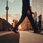 man in dress suit outfit walking in front of building